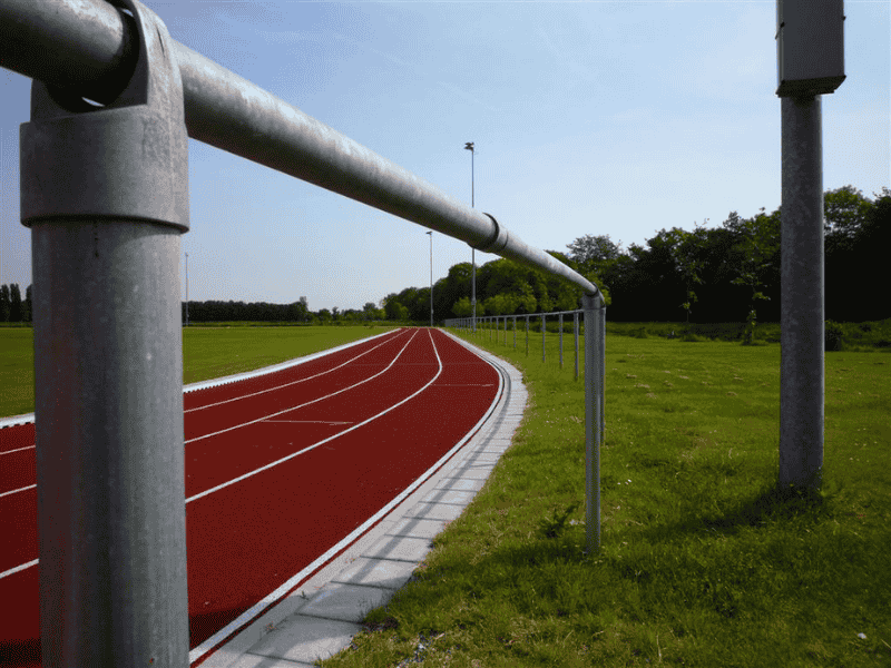 Afrastering langs atletiekbaan van staal, voor veilige afbakening en toegangscontrole bij sportterrein en openbare ruimte