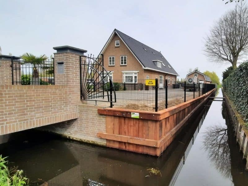 Dubbelstaafmat hekwerk langs watergang bij woning in Utrecht, voor veilige erfafscheiding en afsluiting van tuin.
