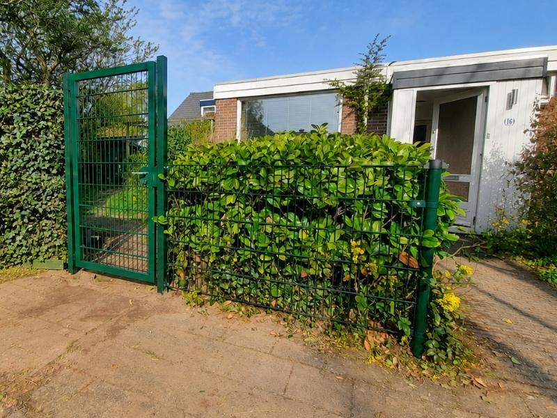 Dubbelstaafmat hekwerk met groene poort bij woning in Lisse, voor veilige afsluiting van tuin en toegangspad.