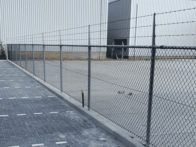 Zakelijk gaashekwerk langs een bedrijfspand geplaatst door De Kim Hekwerk voor een nette en veilige terreinafscheiding.